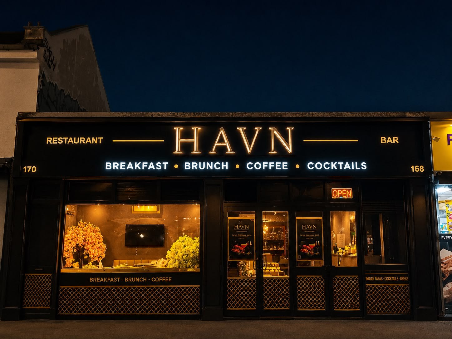 HAVN's storefront on Fawcett Road at night — warm light spilling from the windows under the HAVN sign